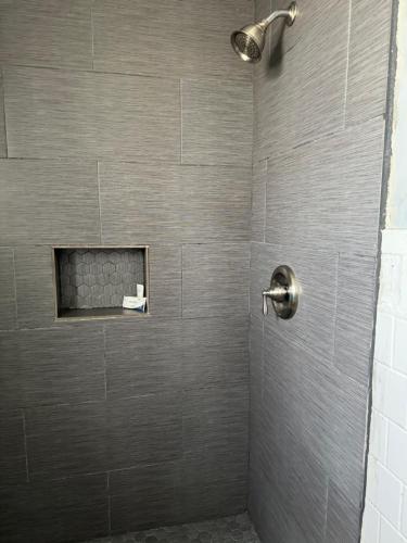 a bathroom with a shower with a gray tile wall at Budget Inn Danville in Danville