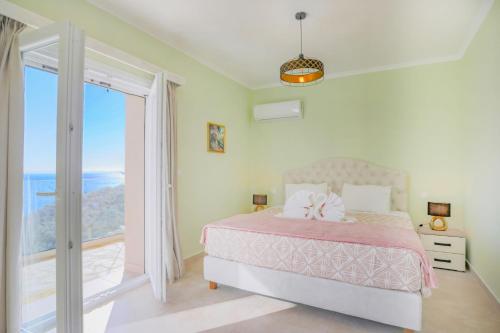 a bedroom with a bed with a view of the ocean at Villa TheView in Katávolos