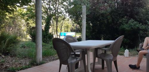 une table blanche et des chaises assises sur une terrasse dans l'établissement L'apicasa de Bassan, à Bassan