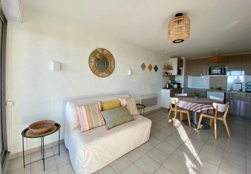 ein Wohnzimmer mit einem weißen Sofa und einem Tisch in der Unterkunft Escale paisible à Sète, belle terrasse vue sur mer in Sète