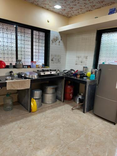 a large kitchen with counters and a refrigerator at Janhavi Villa in Dapoli