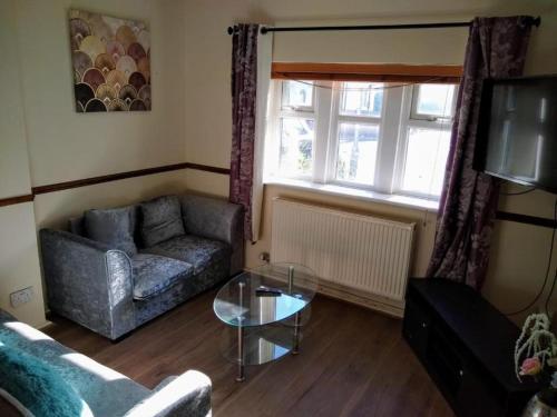 a living room with a couch and a glass table at London Central Acton Aparthotel in London