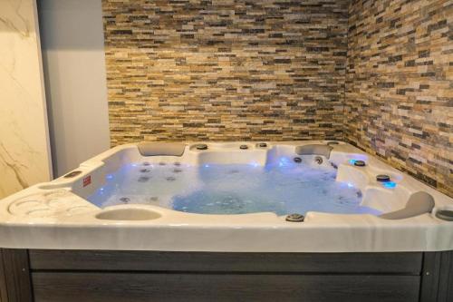 Cette chambre dispose d'un bain à remous et d'un mur en briques. dans l'établissement Geregs alibi - free Spa, à Kopaonik