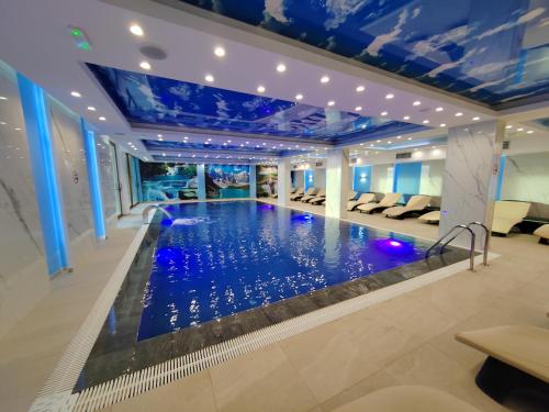 - une piscine dans une chambre d'hôtel dotée de plafonds bleus dans l'établissement Geregs alibi - free Spa, à Kopaonik