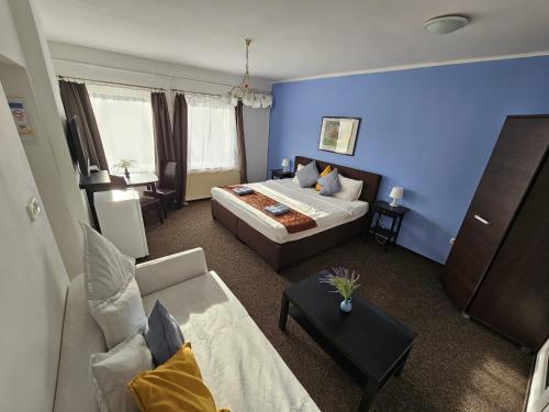 une chambre d'hôtel avec un lit et un canapé dans l'établissement Joy Guesthouse, à Siófok