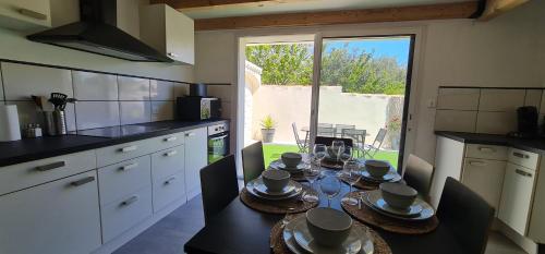 - une cuisine avec une table et de la vaisselle dans l'établissement Le cocon des bois, à Martigues