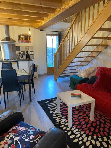 un salon avec un canapé rouge et une table dans l'établissement Gîte mitoyen gorges de la Monne - Olloix, à Olloix