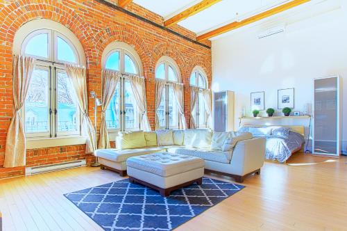 a living room with a brick wall with windows at Les Lofts 1048 in Quebec City