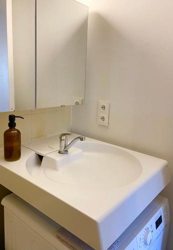 une salle de bain avec un lavabo blanc et un miroir dans l'établissement Le refuge 'Les 4 têtes' - balcon - vue montagne - proche centre & gare, à Sallanches