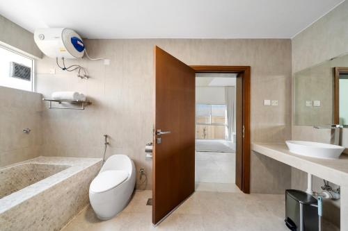 a bathroom with a tub and a toilet and a sink at Jumeirah Three Bedroom House in Dubai