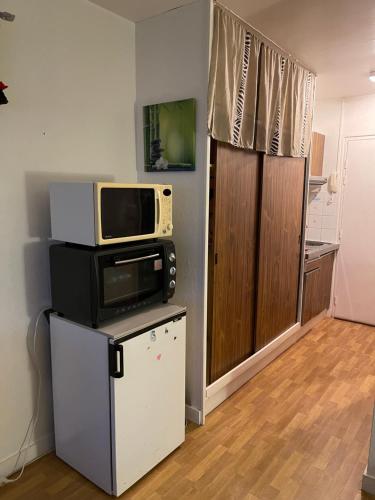 Zimmer mit einer Mikrowelle auf dem Kühlschrank in der Unterkunft Turquoise in Bénodet