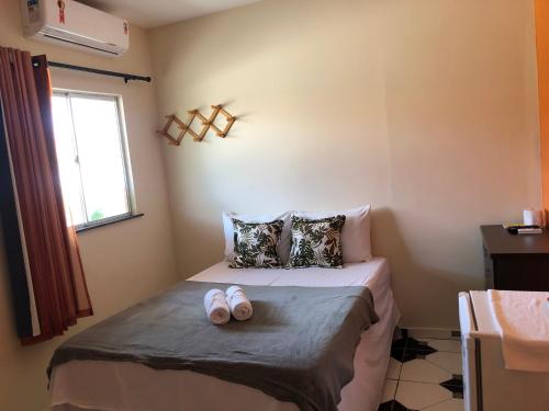 a bedroom with a bed with two slippers on it at Pousada Chácara do Coqueiro in Barreirinhas