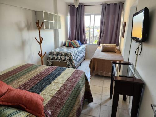 Cette chambre comprend 2 lits et une télévision à écran plat. dans l'établissement Apezinho da Soltony em Peruibe, à Peruíbe