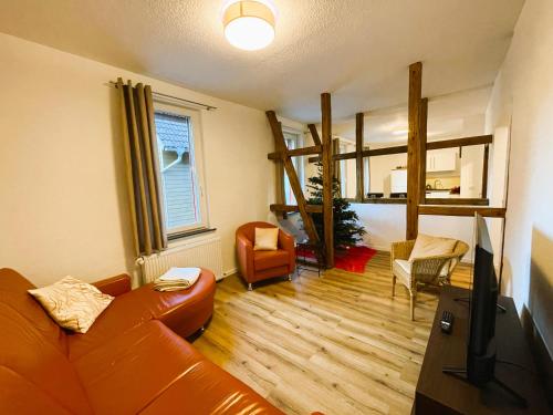 een woonkamer met een bank en een hoogslaper bij Harzhaus Drei Hexen in Tanne
