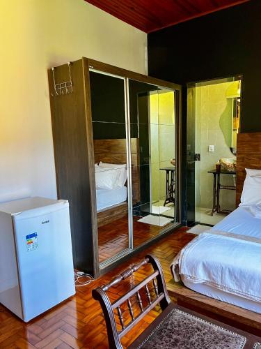 a room with a bed and a refrigerator in it at HOSTEL BADULACK in Capitólio