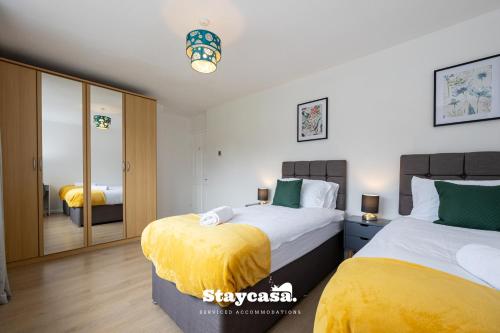 um quarto com 2 camas e um espelho em Bright & Spacious 3 Bedroom Home With Fast Wifi! em Wythenshawe