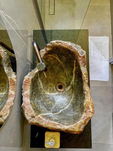 a statue of a stone sink in a room at HOSTEL BADULACK in Capitólio