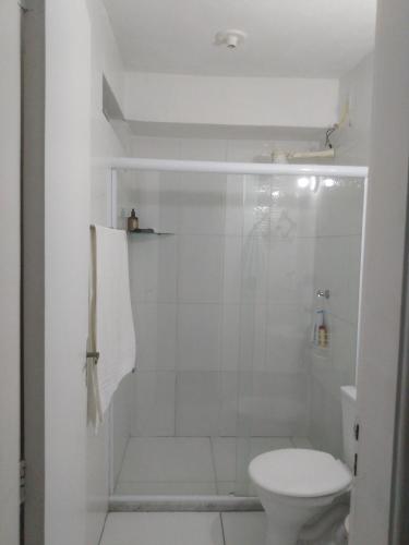 y baño blanco con ducha y aseo. en Quarto Casal privativo em apartamento, en Salvador