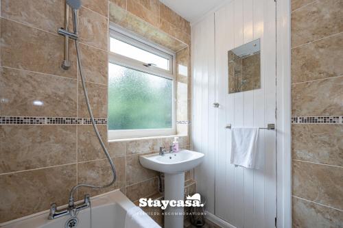 uma casa de banho com um chuveiro, um lavatório e uma banheira em Bright & Spacious 3 Bedroom Home With Fast Wifi! em Wythenshawe