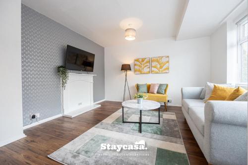 a living room with a couch and a table at Spacious Cosy Cove with Large Driveway and Garden in Wythenshawe