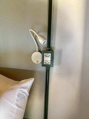 a lamp on a wall next to a pillow at HOSTEL BADULACK in Capitólio