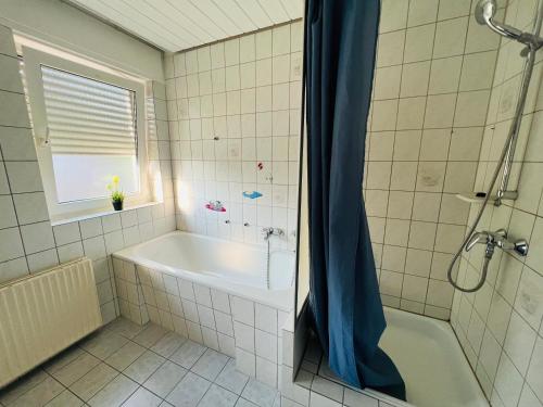 een badkamer met een bad en een douche bij Beautiful Apartment I 19 Beds I Parking I Fast WiFi in Gütersloh