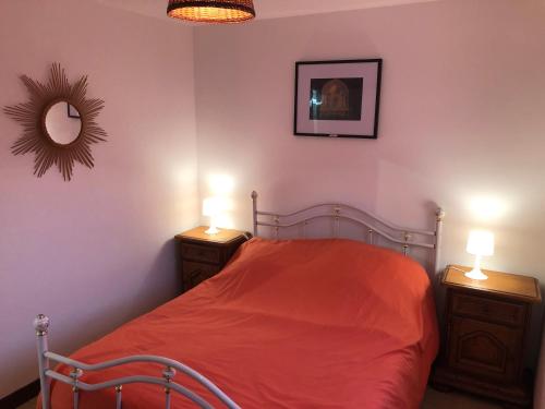 een slaapkamer met een bed met 2 dressoires en 2 lampen bij L’occitanine in Capdenac-Gare