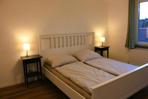 a bedroom with a bed with two lamps on two tables at Harzhaus Drei Hexen in Tanne