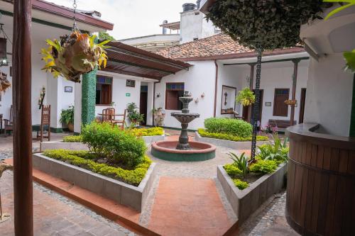 a courtyard with a fountain in the middle of a building at Hotel Casa Antigua Buga in Buga