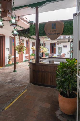 a restaurant with a counter with a potted plant at Hotel Casa Antigua Buga in Buga