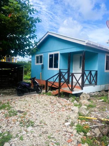 ein blaues Haus mit einem Motorrad davor geparkt in der Unterkunft Casa Nativa DUDA´S in Franshua