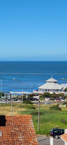 vistas a una playa con un edificio y al océano en Duplex premium Punta mogotes waikiki en Mar del Plata