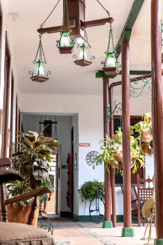 a hallway with potted plants and lights at Hotel Casa Antigua Buga in Buga