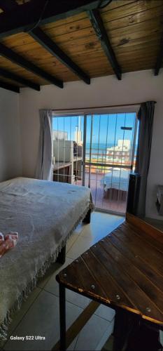1 dormitorio con cama y banco de madera en Duplex premium Punta mogotes waikiki en Mar del Plata