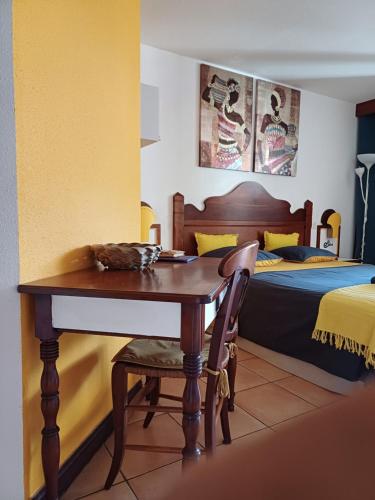 a bedroom with a desk and a bed with a bed gmaxwell gmaxwell at Au petit Régal in Sainte-Anne
