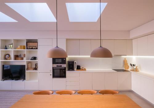 a kitchen with a table and two pendant lights at Sky PDL in Ponta Delgada