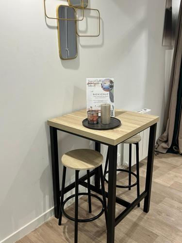 a table with two stools and a box on it at STNAHOME 60110 L'escale Douillette in Amblainville