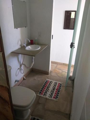 a bathroom with a white toilet and a sink at Morada dos Elfos in Vale do Capao