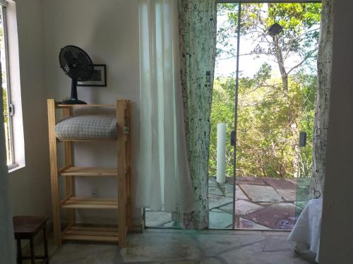 um quarto com uma porta de vidro que leva a um pátio em Morada dos Elfos em Vale do Capao