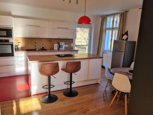 a kitchen with a counter and two bar stools at The Cottage in Reichenau
