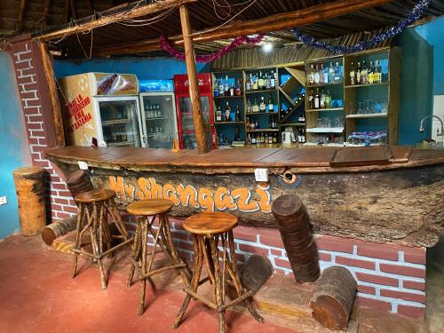 卡拉圖的住宿－Patamu Restaurant & Lodge，砖墙前有凳子的酒吧