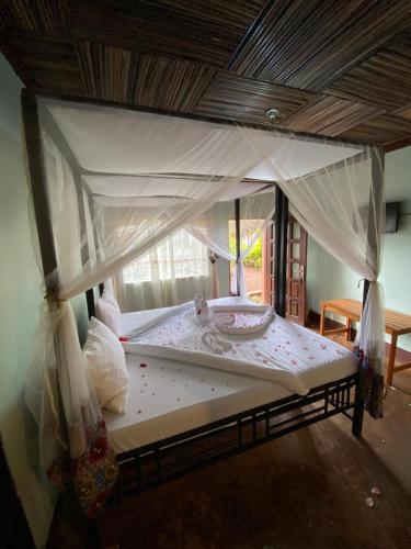 a bed with a canopy in a room at Patamu Restaurant & Lodge in Karatu