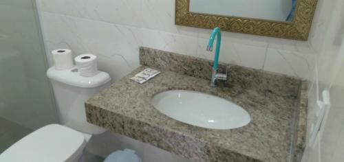 a bathroom with a sink with a toothbrush on it at Pousada Porto Taquari in Paraty