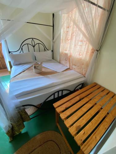 a small bedroom with a bed and a window at Patamu Restaurant & Lodge in Karatu
