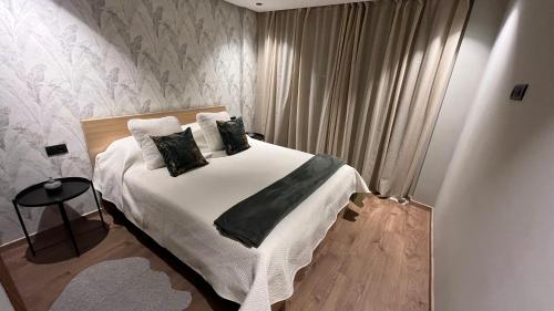 a bedroom with a bed with white sheets and pillows at New Apartment by the Twin Center with Free Parking in Casablanca