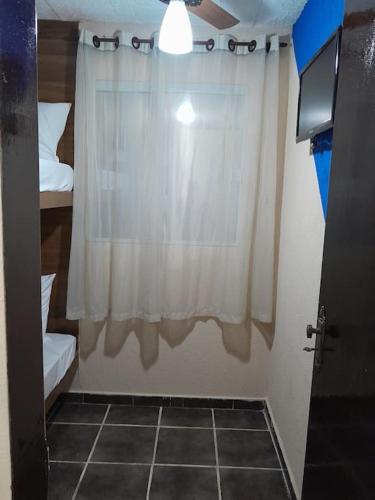 リオ・ダス・オストラスにあるAconchego da Gilの白いカーテン付きの窓のある部屋
