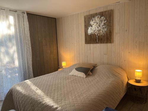 um quarto com uma cama, 2 candeeiros e uma janela em Gîte Au Coeur Du Pays Cathare em Fanjeaux