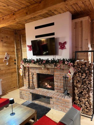 a living room with a fireplace with a tv above it at Cabana Craita in Vişeu de Sus