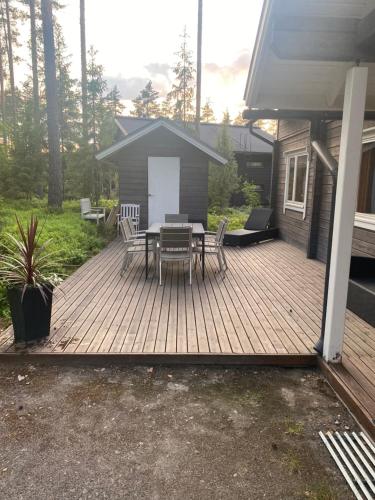 una terraza de madera con mesa y sillas. en Villa Sappee, en Sappee