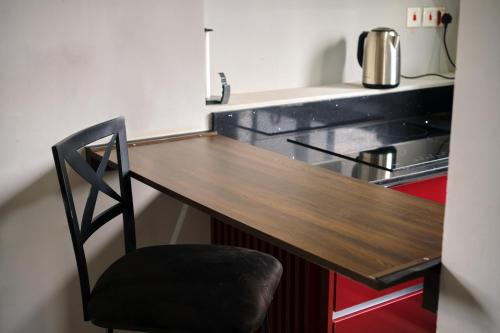 a kitchen with a wooden counter top and a chair at The Pearls in East Legon